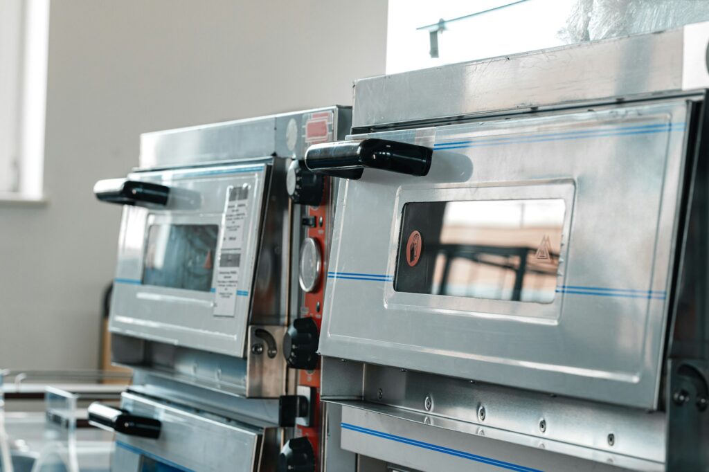 Two industrial pizza ovens in a shop